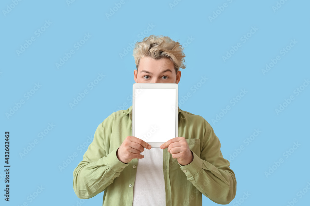 Poster young man with tablet computer on color background