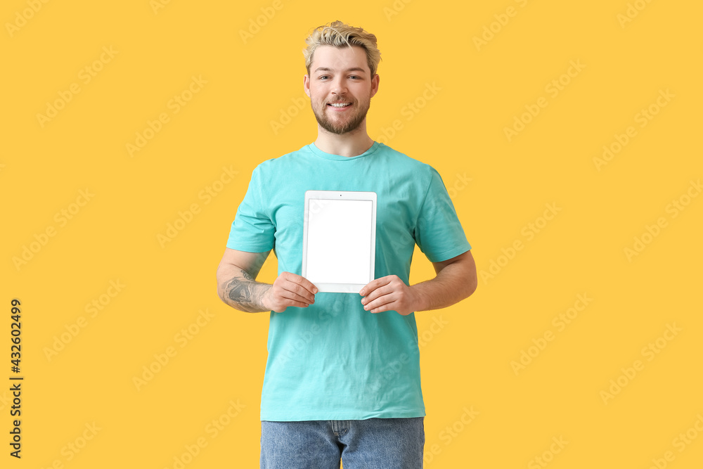 Poster young man with tablet computer on color background
