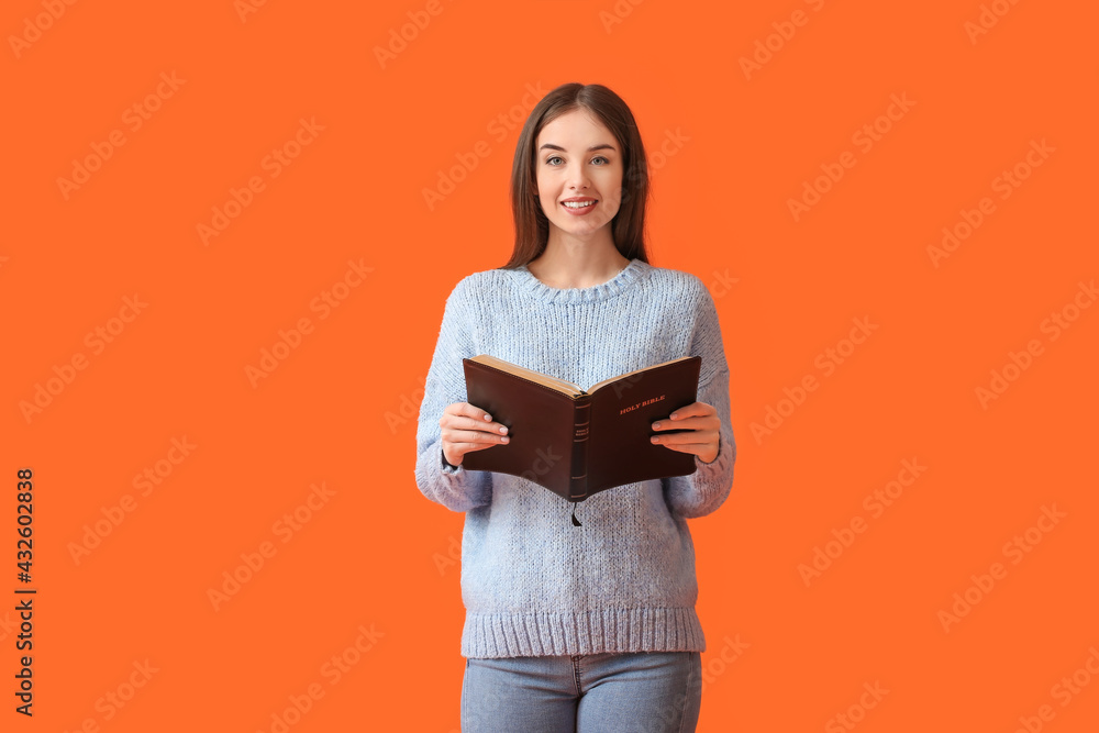 Wall mural young woman with bible on color background - Wall murals