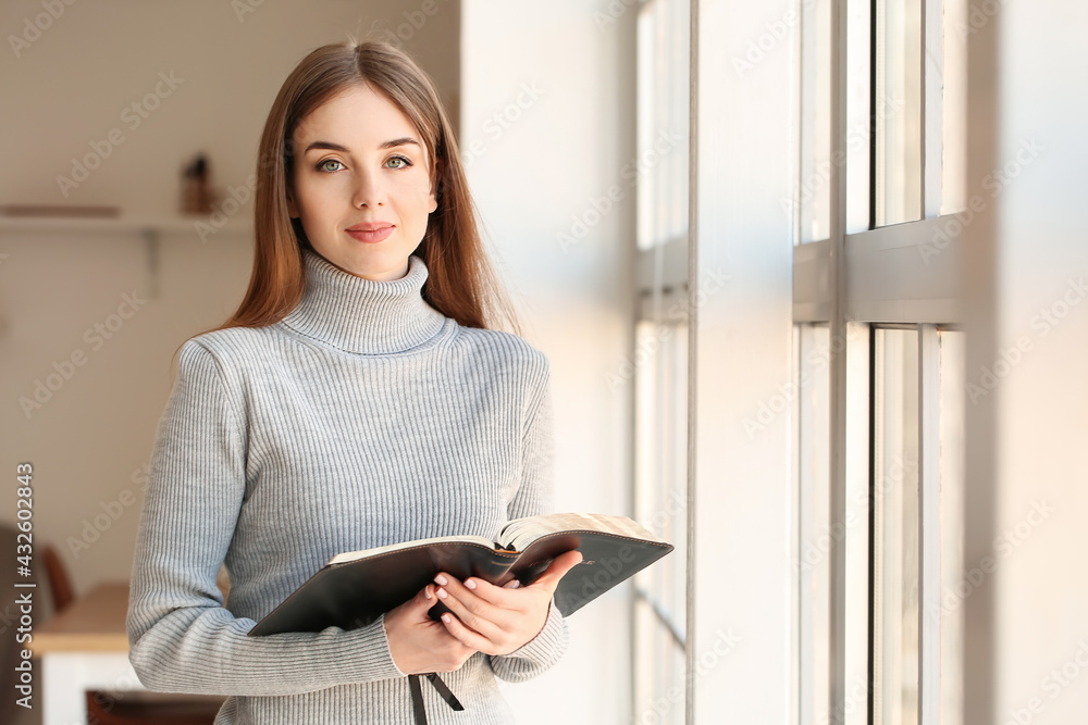 Wall mural young woman reading bible at home