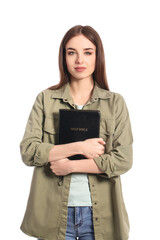 Young woman with Bible on white background