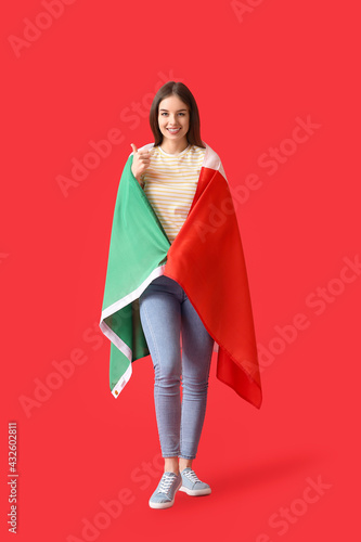 Beautiful young woman with Italian flag on color background