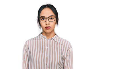 Young hispanic girl wearing casual clothes and glasses relaxed with serious expression on face. simple and natural looking at the camera.