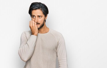 Young hispanic man wearing casual clothes looking stressed and nervous with hands on mouth biting...