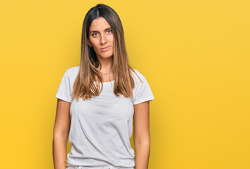 Young woman wearing casual white t shirt with serious expression on face. simple and natural looking at the camera.