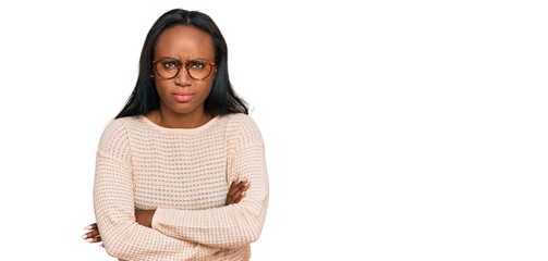Young black woman wearing casual clothes and glasses skeptic and nervous, disapproving expression on face with crossed arms. negative person.