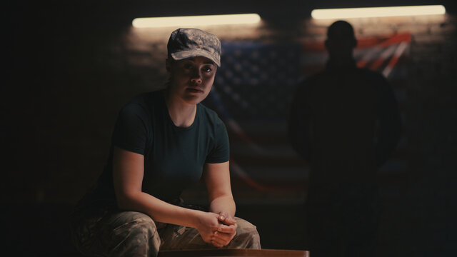 Female soldier sitting near anonymous commander