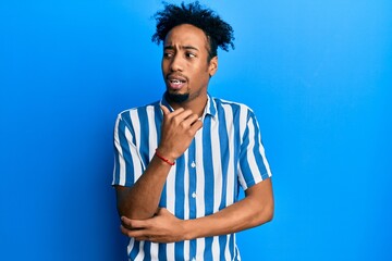 Fototapeta na wymiar Young african american man with beard wearing casual striped shirt looking stressed and nervous with hands on mouth biting nails. anxiety problem.