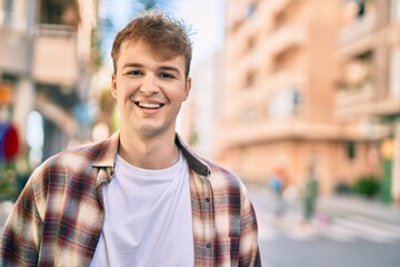 Fototapeta premium Young caucasian man smiling happy standing at the city.