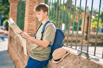 Young caucasian tourist man smiling happy holding map at the city.