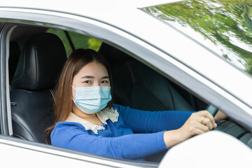 A girl wearing a mask while driving a car To prevent the corona virus