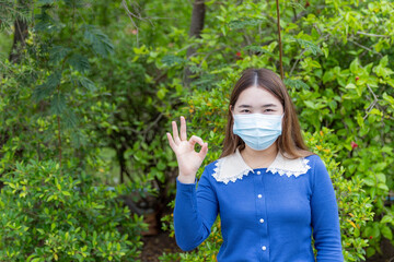 Young women wear a mask while outdoors to prevent the coronavirus.