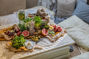 Serving table with healthy food drink at cozy boho scandi interior. Hippie birthday party holiday