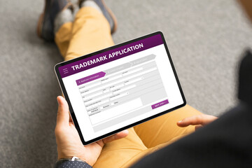 Man submitting trademark application online - obrazy, fototapety, plakaty