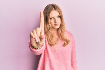 Beautiful young caucasian girl wearing casual clothes pointing with finger up and angry expression, showing no gesture