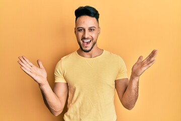 Young arab man wearing casual clothes celebrating victory with happy smile and winner expression with raised hands