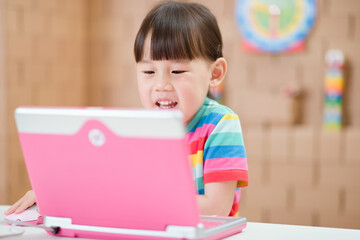 Naklejka premium young girl using laptop for online learning during lockdown time
