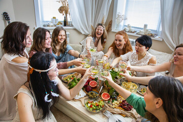 Top view group modern hippie female friends celebrating holiday at table serving with healthy food