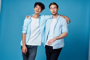 best friends hugging on blue background in matching t-shirts cropped view