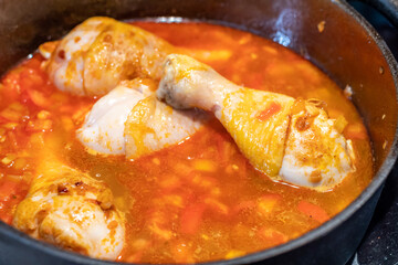 Chicken legs with roasted onion in the iron pan. Dinner or lunch cooking, detail view.