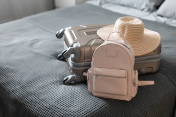 Modern suitcase full of things, handbag and straw hat. Baggage case packing getting ready to travel