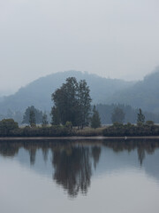 Misty lake view in the morning with reflection.