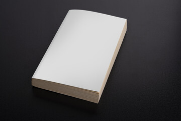 Closeup shot of a book with a blank cover on black background