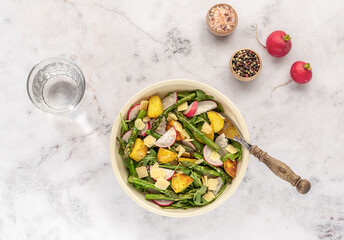 Summer salad with potatoes, green asparagus, arugula, and radishes. Seasonal healthy food. Plant-based diet.
