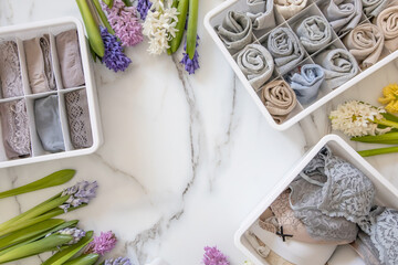 Stylish composition storage underwear organization Marie Kondo's method decorated by natural flowers