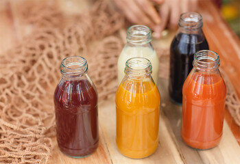 Many different Jamu drinks- Indonesian herbal beverage in glass bottles with natural ingredients: turmeric, ginger, lime, palm sugar, lemongrass, tamarind on wooden table. Healthy lifestyle