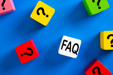 Question mark icon on blue wooden block on blue background.