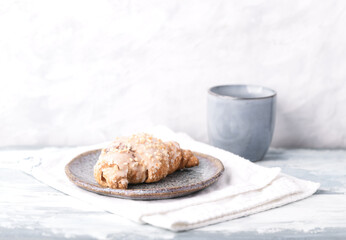 Croissant on bright wooden background. Copy space.