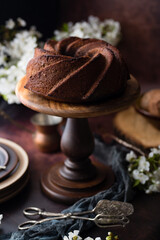 Homemade bundt cake with flowers on a dark background.