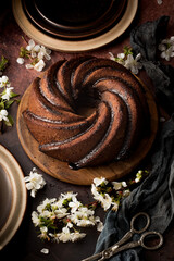 Homemade bundt cake with flowers on a dark background.