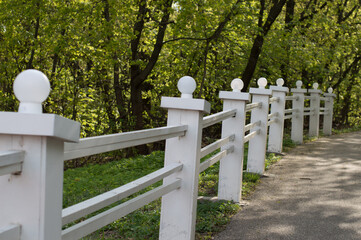 White wooden fence on the path in the park