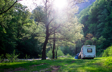 Tourist caravan and tent on the water's edge, in the mountains. Spending time in nature