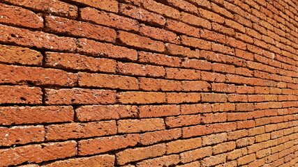 Side view of red-brown stone wall. Background or laterite brick wall texture in your design. Selective focus