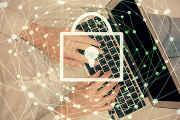Double exposure of woman hands working on computer and lock hologram drawing. Top View. Security concept.