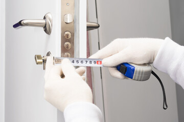 hands in gloves measure the thickness of the door close-up