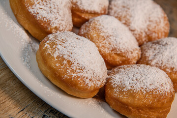 Obraz na płótnie Canvas Freshly cooked Apricot jam doughnuts, referred to as jelly doughnuts, donuts in the US, The doughnuts have been fried, injected with a generous amount of jelly, jam and then dipped in caster sugar