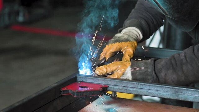 Footage of a man work with grinding a sheet of metal. Close-up. Slow motion