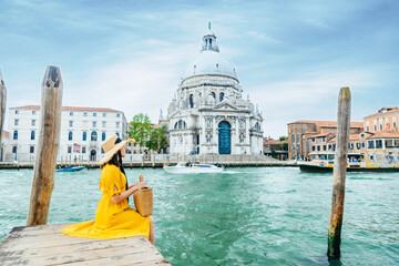 woman in yellow sundress sitting on pier with view of grand canal