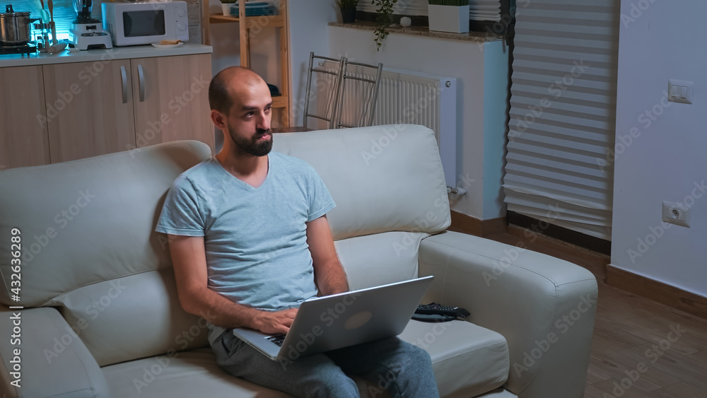 Poster caucasian male sitting in front of television while working at communication project before deadline