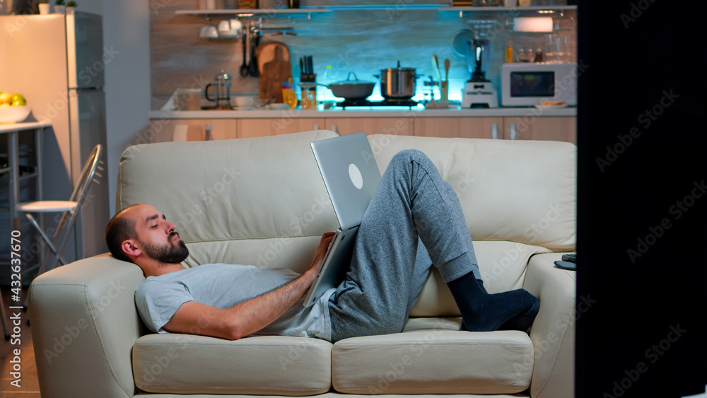 Aufkleber exhausted man falling asleep while working on internet communication project using laptop computer w