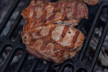 Pork steak toasted on one side is cooked on a cast iron wire rack