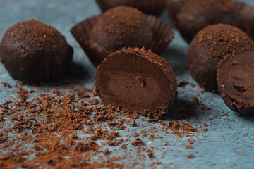 Chocolate petit fours on a table. Chocolate petit four sweets with truffle filling. Small...