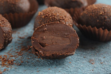 Chocolate petit fours on a table. Chocolate petit four sweets with truffle filling. Small...