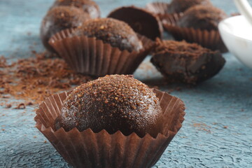 Chocolate petit fours on a table. Chocolate petit four sweets with truffle filling. Small...