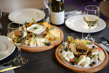 Cheese plate served with white wine, crackers and nuts. Top view. Assorted cheeses Camembert, Brie, Parmesan blue cheese, goat, blueberries, strawberries, jam