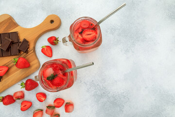Fototapeta na wymiar Strawberry drinks with berries and wooden board with chocolate. Drink and healthy concept. Flat lay